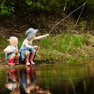 2 little girls fishing in a pond